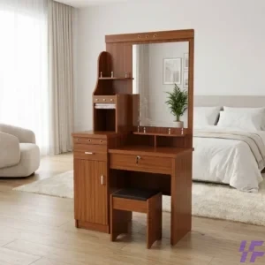 A modern elegant brown wooden dressing table with multiple drawers, shelves, a large mirror, and a matching cushioned stool, placed in a bright, minimalist bedroom with a bed and armchai