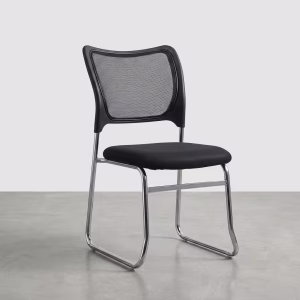 A professional black Ergonomic Mesh Visitor Chair with armrests placed neatly next to a sleek mahogany executive desk inside a modern corporate office.